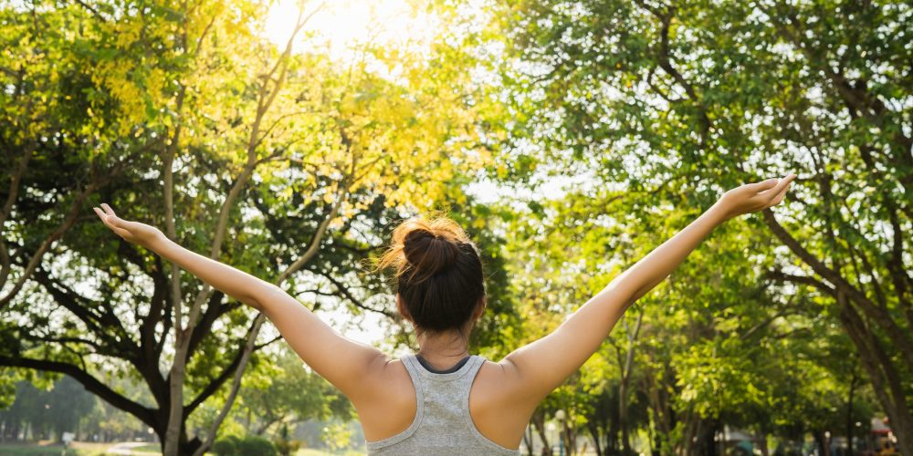 Healthy young Asian runner woman warm up the body stretching before exercise and yoga near lake at park under warm light morning. Lifestyle fitness and active women exercise in urban city concept.